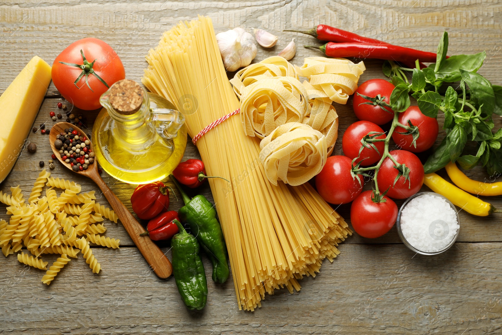Different types of pasta and ingredients on wooden table, flat lay Photo of Different types of pasta and ingredients on wooden table, flat lay