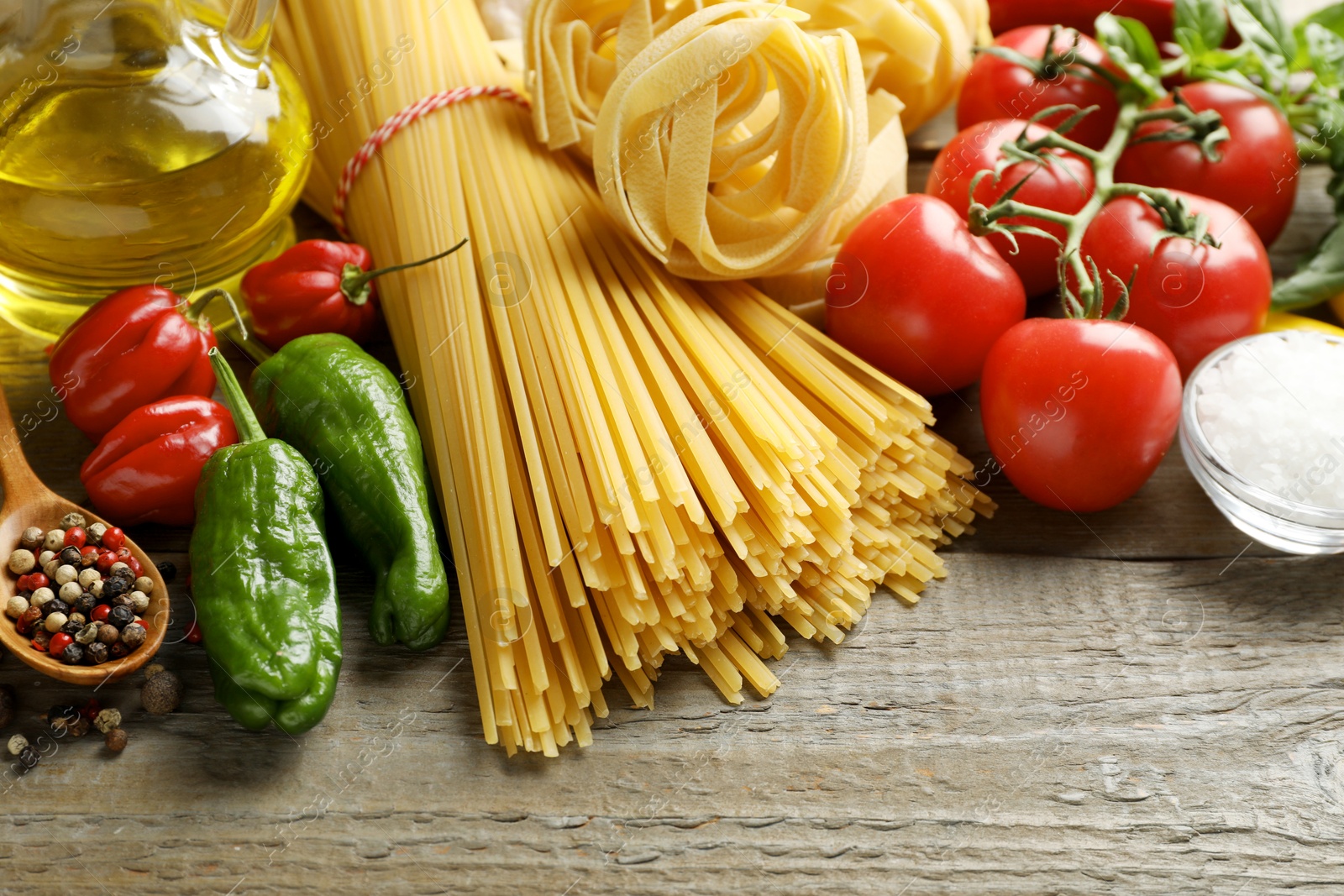 Different types of pasta and ingredients on wooden table, closeup Photo of Different types of pasta and ingredients on wooden table, closeup