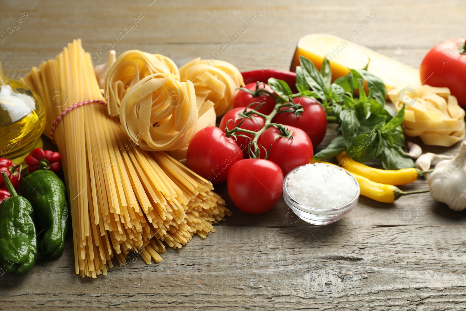 Different types of pasta and ingredients on wooden table, closeup Photo of Different types of pasta and ingredients on wooden table, closeup