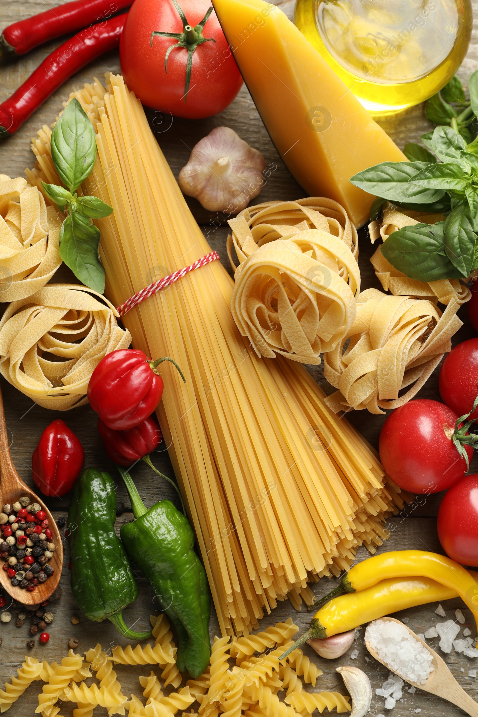 Different types of pasta and ingredients on wooden table, flat lay Photo of Different types of pasta and ingredients on wooden table, flat lay