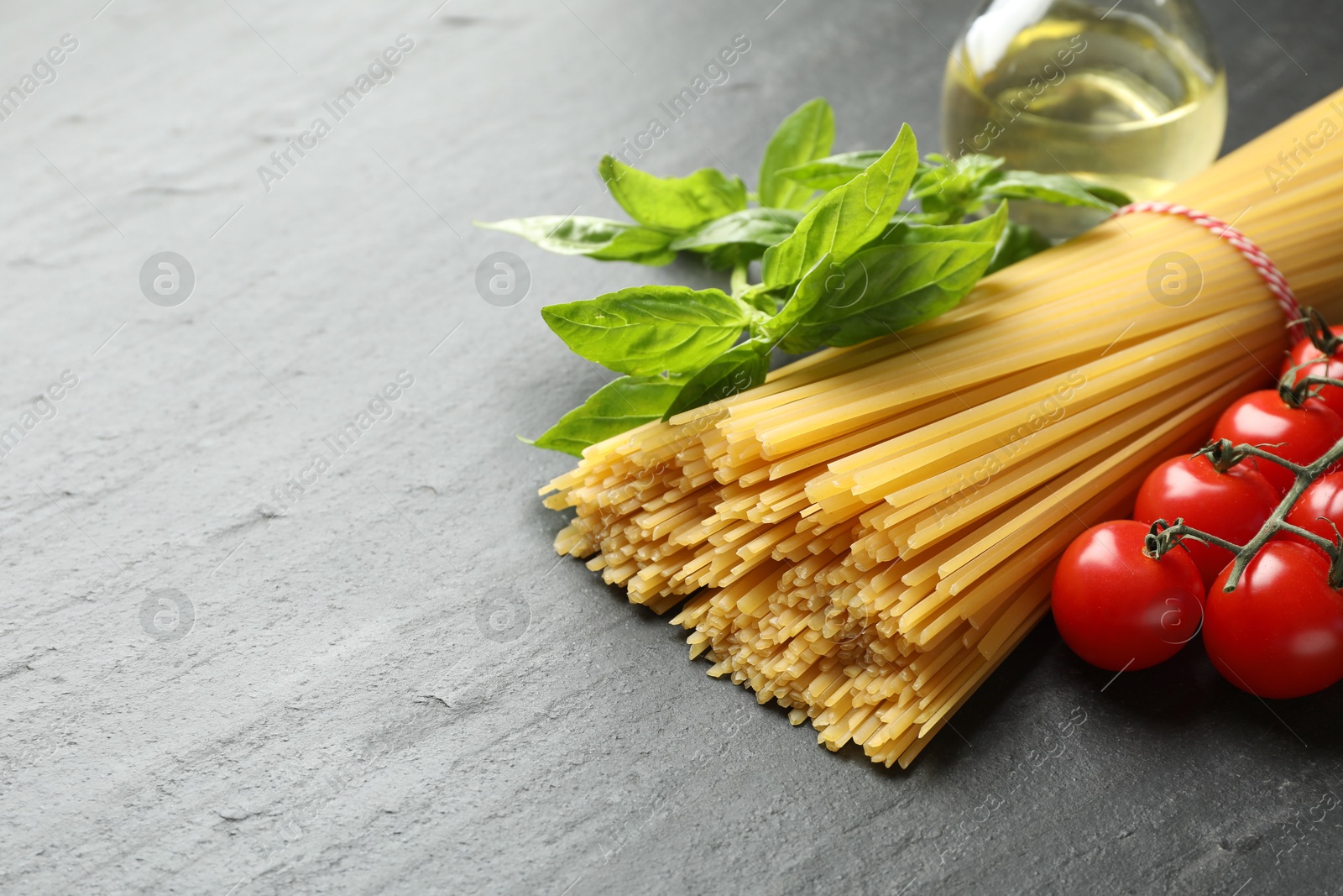 Raw spaghetti pasta and different ingredients on black table, closeup. Space for text Photo of Raw spaghetti pasta and different ingredients on black table, closeup. Space for text