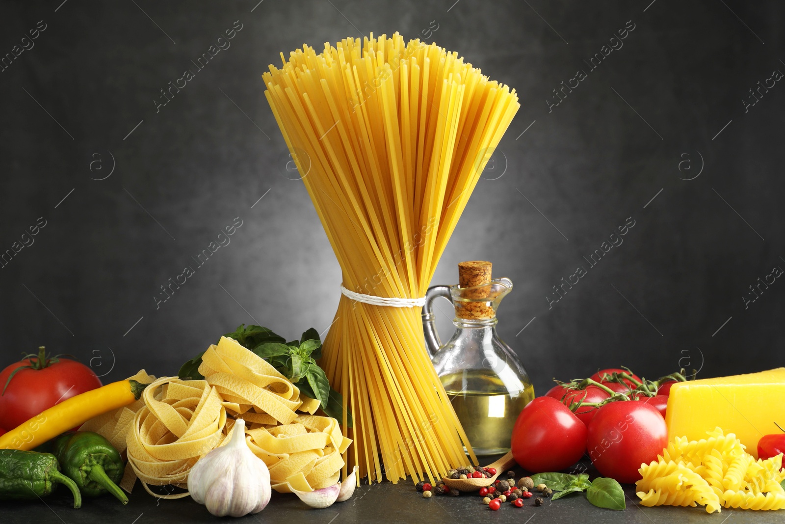 Different types of pasta and ingredients on black table Photo of Different types of pasta and ingredients on black table