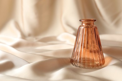 Photo of One beautiful glass vase on beige cloth, space for text