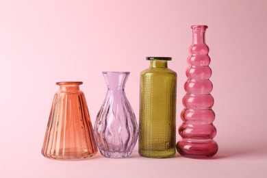 Photo of Different beautiful glass vases on pink background