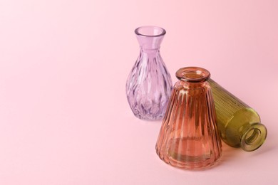 Photo of Different beautiful glass vases on pink background, closeup. Space for text