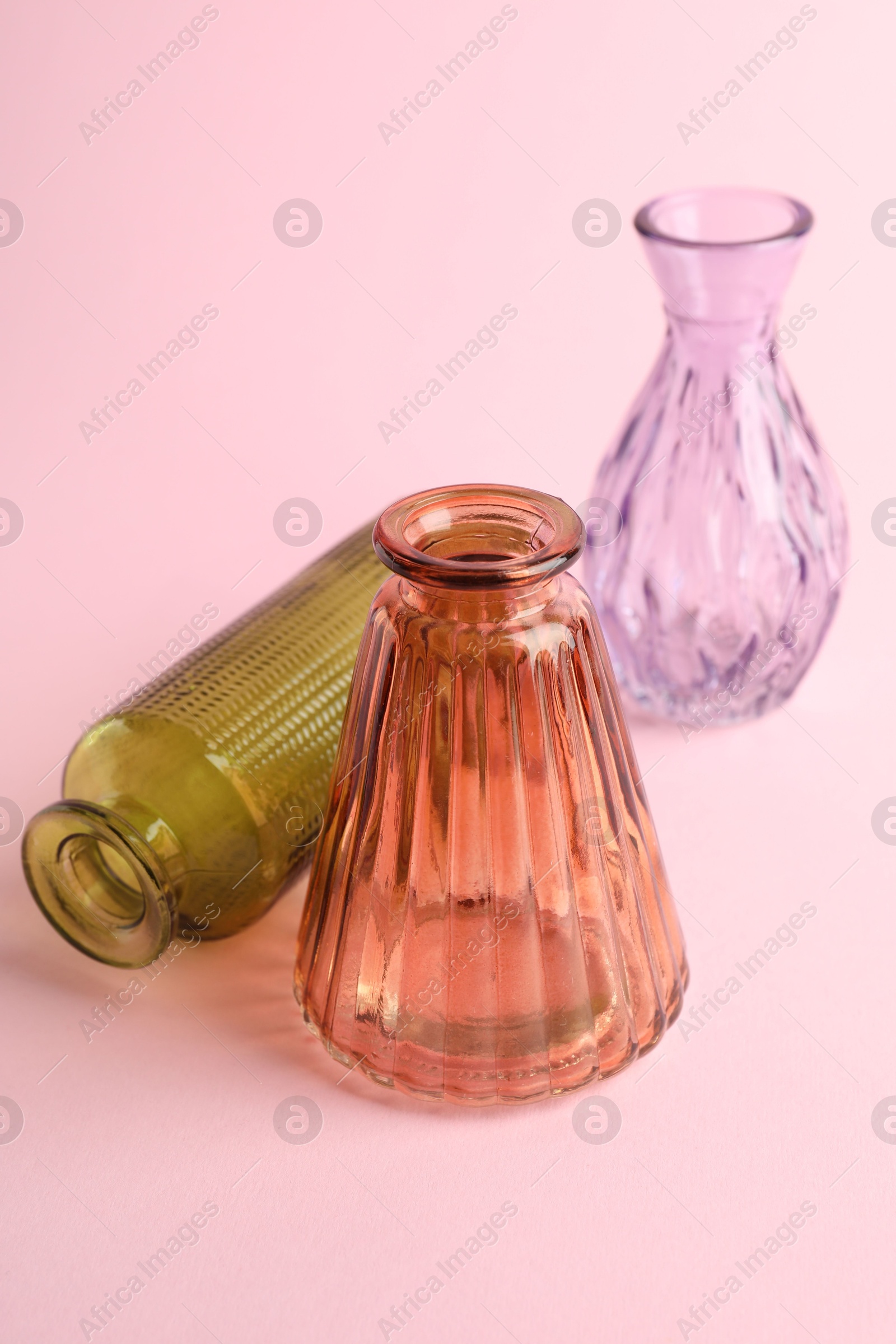 Different beautiful glass vases on pink background, closeup Photo of Different beautiful glass vases on pink background, closeup