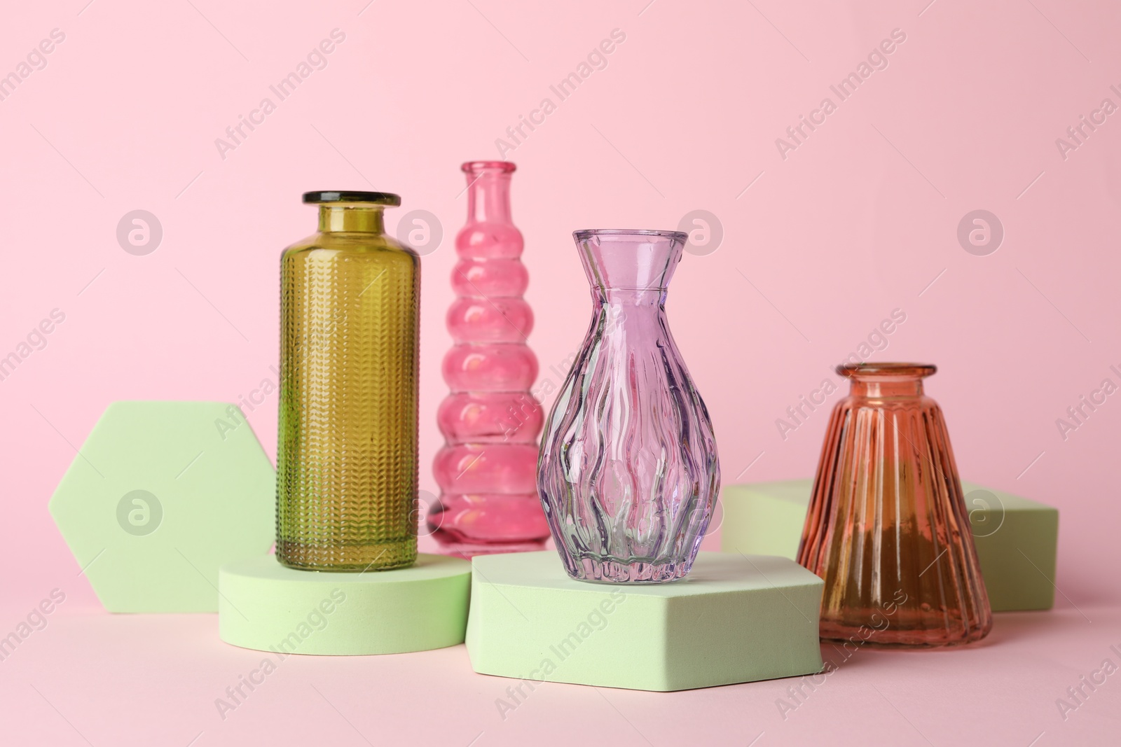 Different beautiful glass vases on pink background Photo of Different beautiful glass vases on pink background