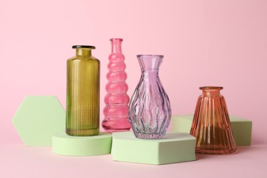 Photo of Different beautiful glass vases on pink background