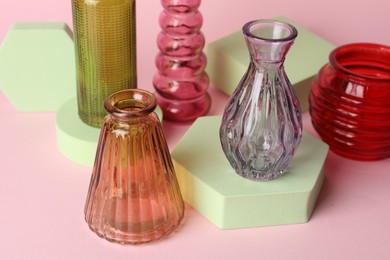 Photo of Different beautiful glass vases on pink background, closeup