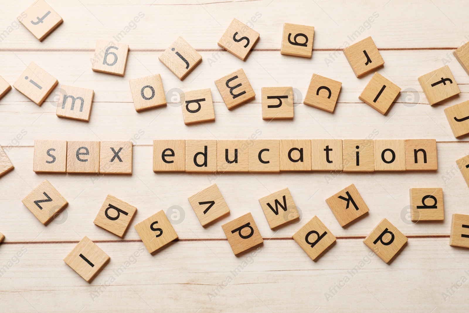 Photo of Words Sex Education made of squares with letters on wooden table, flat lay
