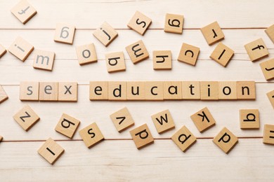 Photo of Words Sex Education made of squares with letters on wooden table, flat lay