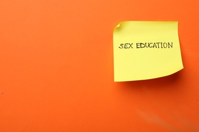 Photo of Sticky note with words Sex Education on orange background, top view. Space for text