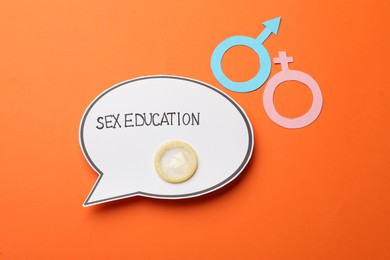Photo of Paper speech bubble with words Sex Education, gender symbols and condom on orange background, flat lay
