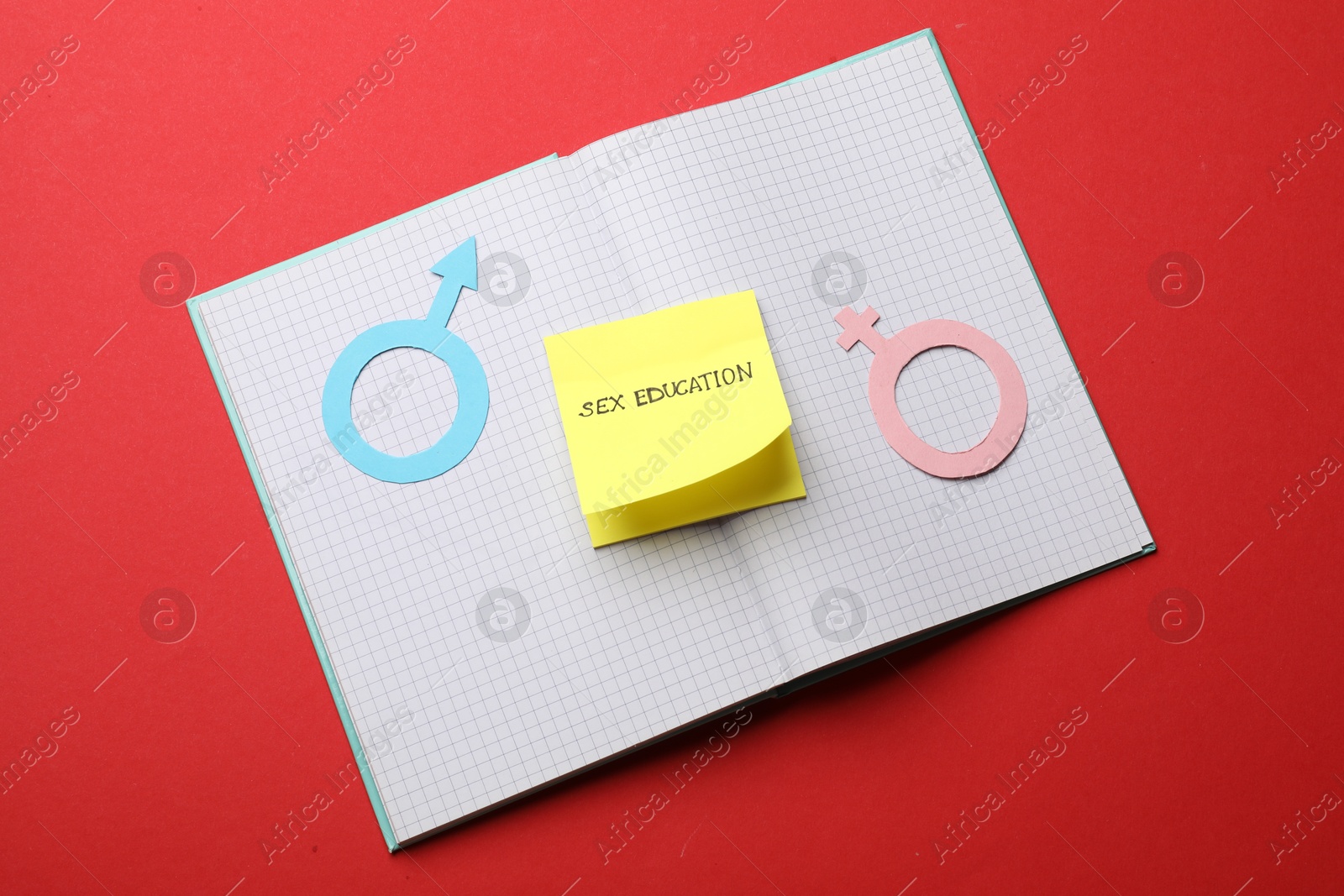 Photo of Sticky note with words Sex Education, gender symbols and notebook on red background, top view