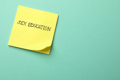 Photo of Sticky note with words Sex Education on turquoise background, top view. Space for text