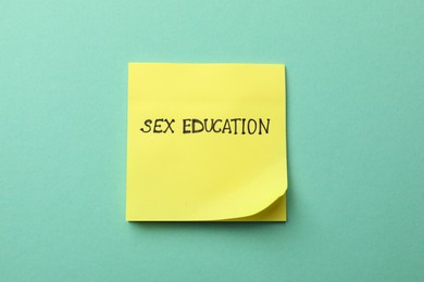 Photo of Sticky note with words Sex Education on turquoise background, top view