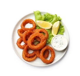 Photo of Fried squid rings, lemon, lettuce and sauce isolated on white, top view