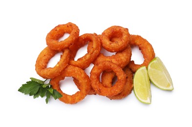 Photo of Fried squid rings, lime and parsley isolated on white, top view