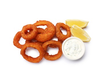 Photo of Fried squid rings, lemon and sauce isolated on white, top view