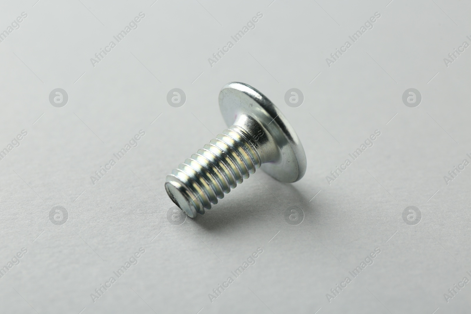 One metal bolt on light grey background, closeup. Hardware tool Photo of One metal bolt on light grey background, closeup. Hardware tool