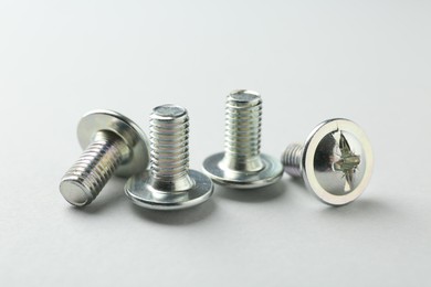 Photo of Many different metal bolts on light grey background, closeup. Hardware tool