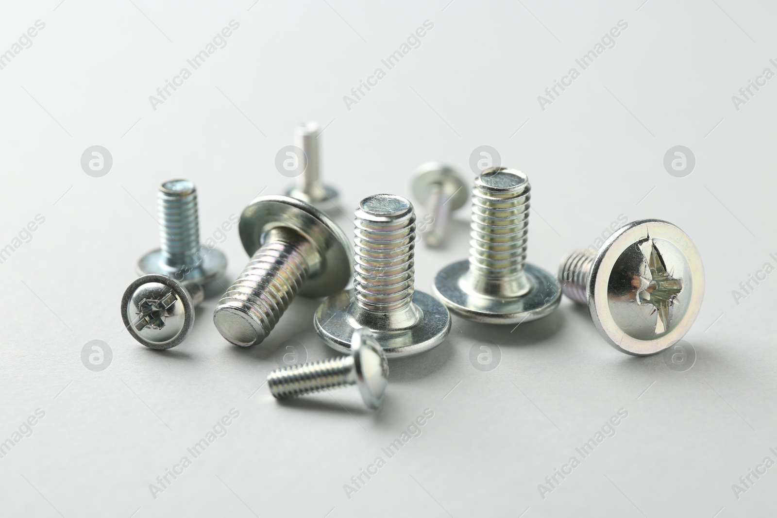 Many different metal bolts on light grey background, closeup. Hardware tool Photo of Many different metal bolts on light grey background, closeup. Hardware tool