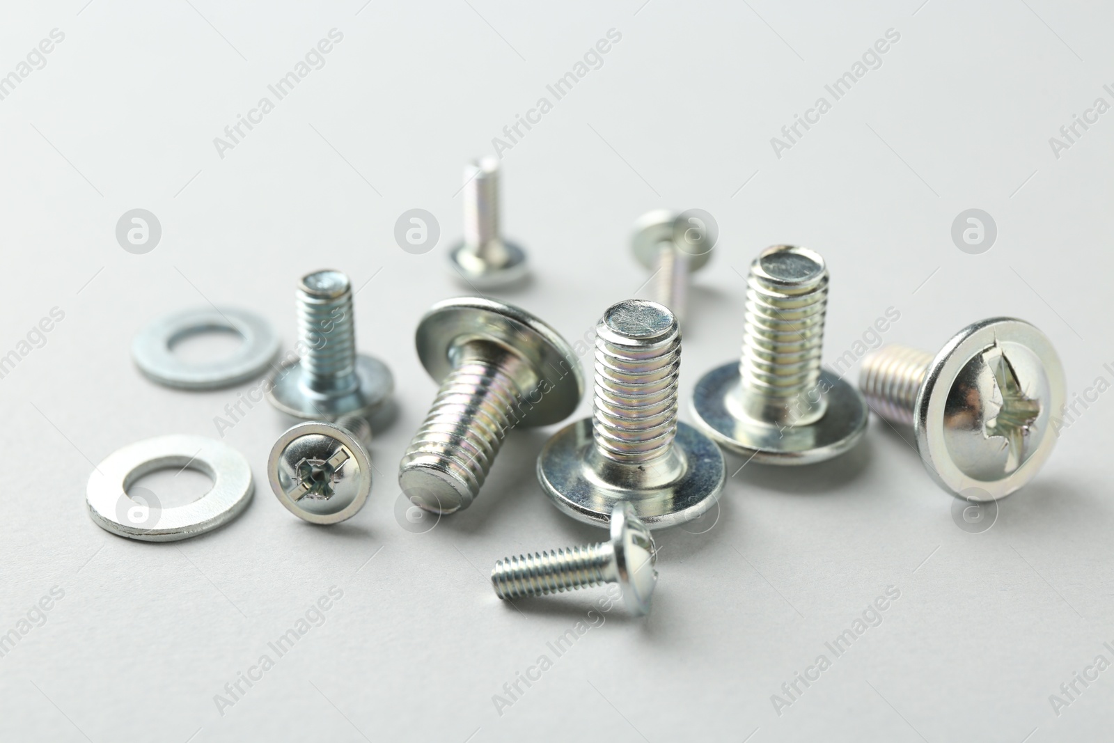 Many different metal bolts on light grey background, closeup. Hardware tool Photo of Many different metal bolts on light grey background, closeup. Hardware tool