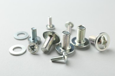 Photo of Many different metal bolts on light grey background, closeup. Hardware tool