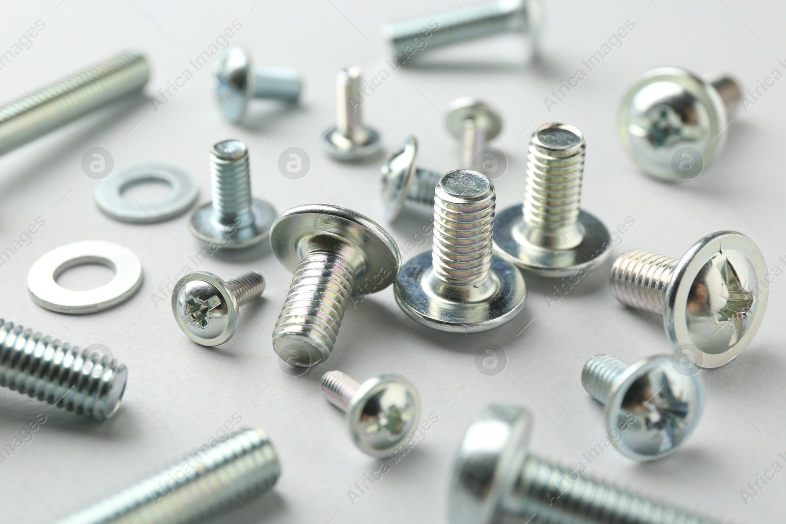 Many different metal bolts on light grey background, closeup. Hardware tool Photo of Many different metal bolts on light grey background, closeup. Hardware tool