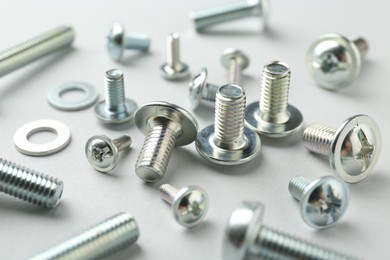 Photo of Many different metal bolts on light grey background, closeup. Hardware tool