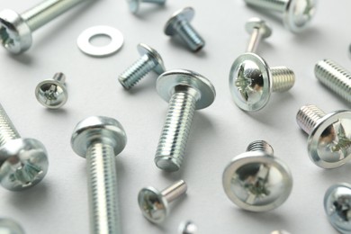 Photo of Many different metal bolts on light grey background, closeup. Hardware tool