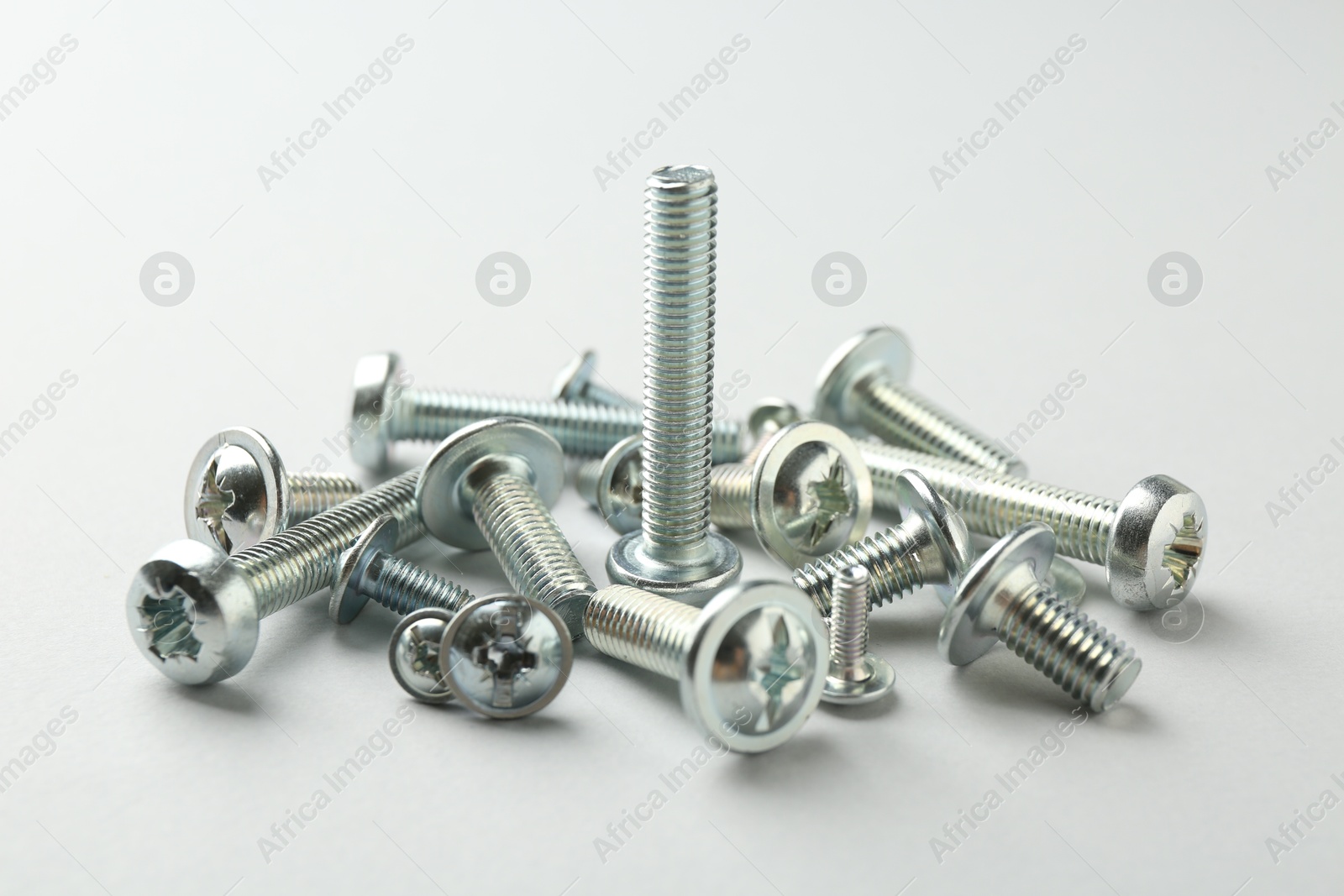 Many different metal bolts on light grey background, closeup. Hardware tool Photo of Many different metal bolts on light grey background, closeup. Hardware tool