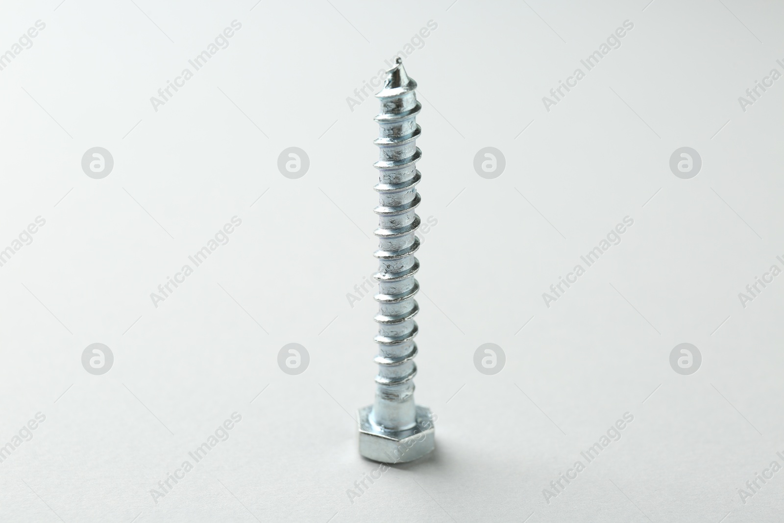 One metal bolt on light grey background. Hardware tool Photo of One metal bolt on light grey background. Hardware tool