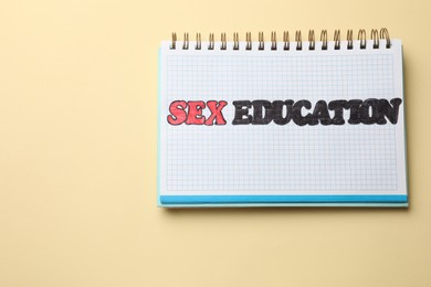 Photo of Notebook with words Sex Education on beige background, top view. Space for text