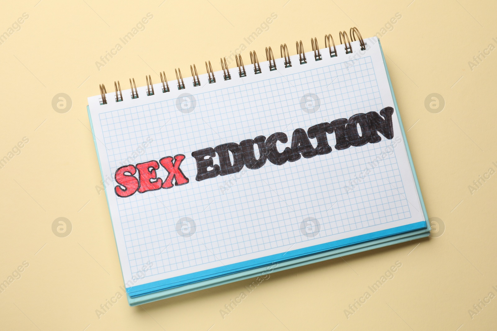 Photo of Notebook with words Sex Education on beige background, top view