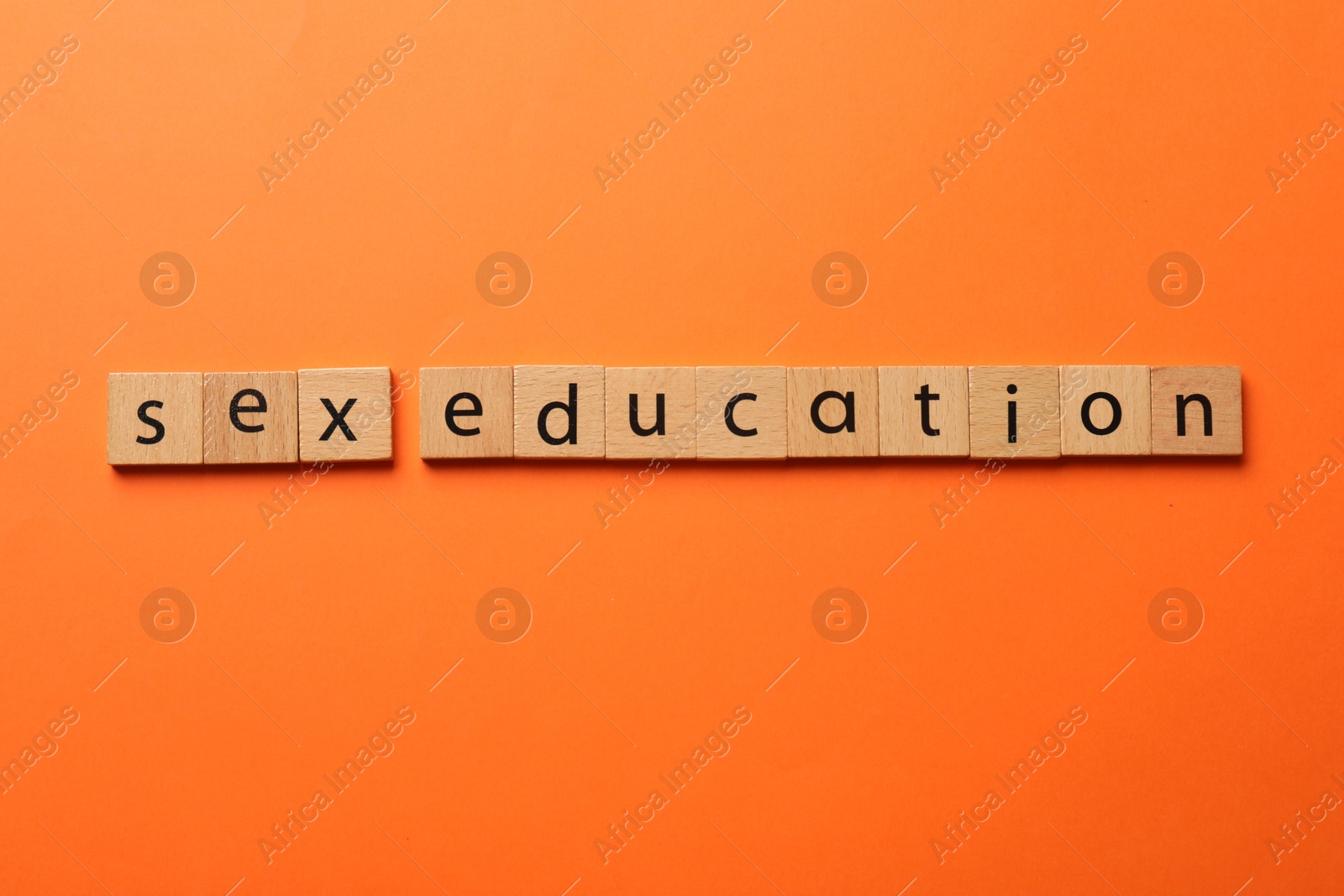Photo of Words Sex Education made of wooden squares on orange background, flat lay