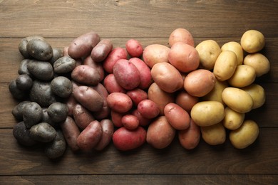 Photo of Different types of potatoes on wooden table, flat lay