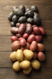 Photo of Different types of potatoes on wooden table, flat lay