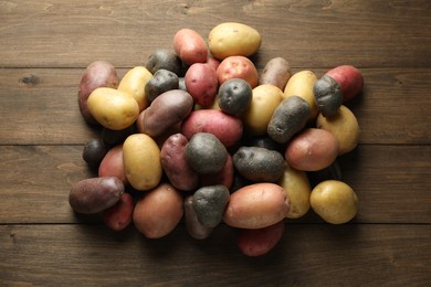 Photo of Different types of potatoes on wooden table, flat lay