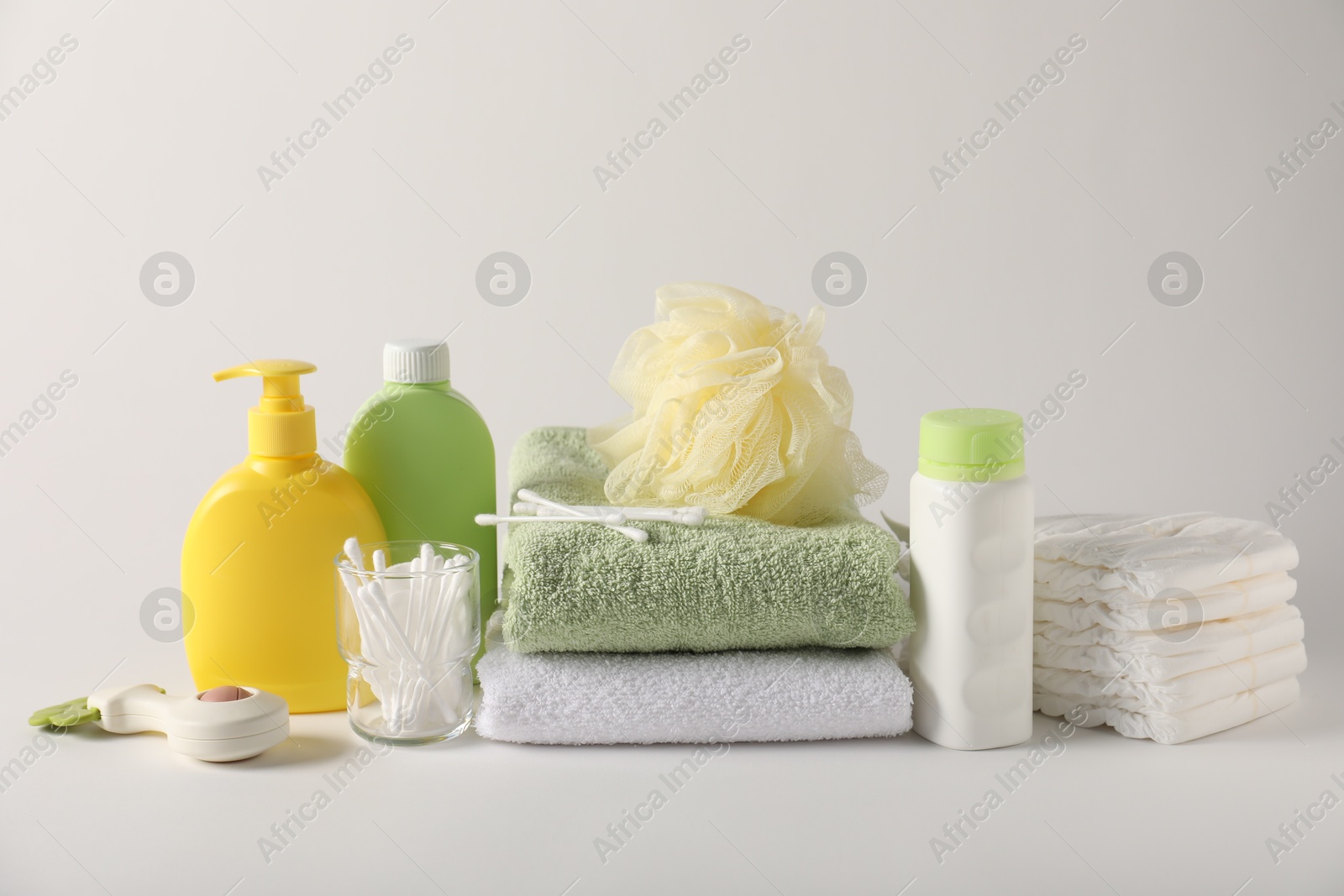 Baby accessories and body care products on light grey background Photo of Baby accessories and body care products on light grey background