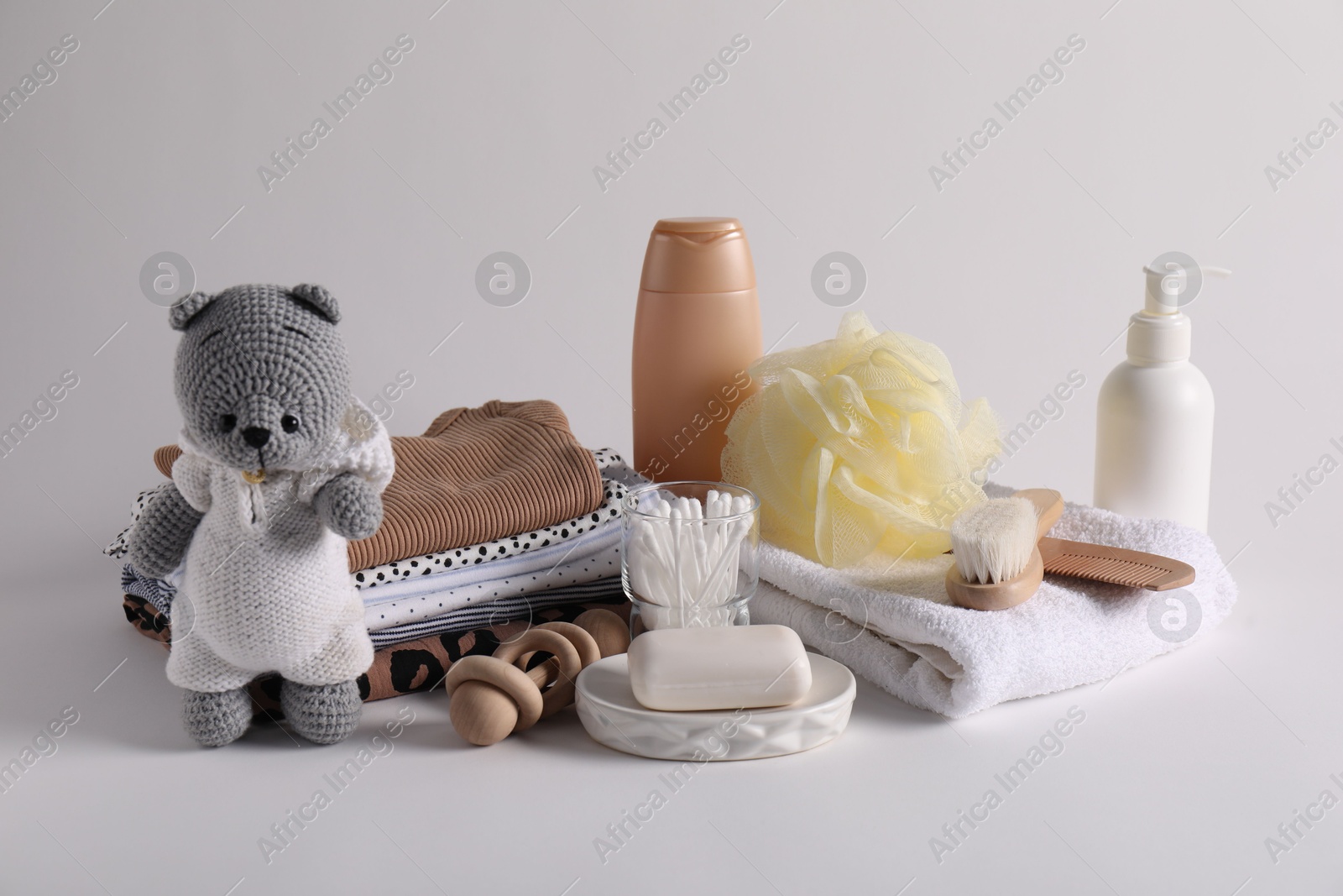 Baby accessories, clothes and body care products on light grey background Photo of Baby accessories, clothes and body care products on light grey background