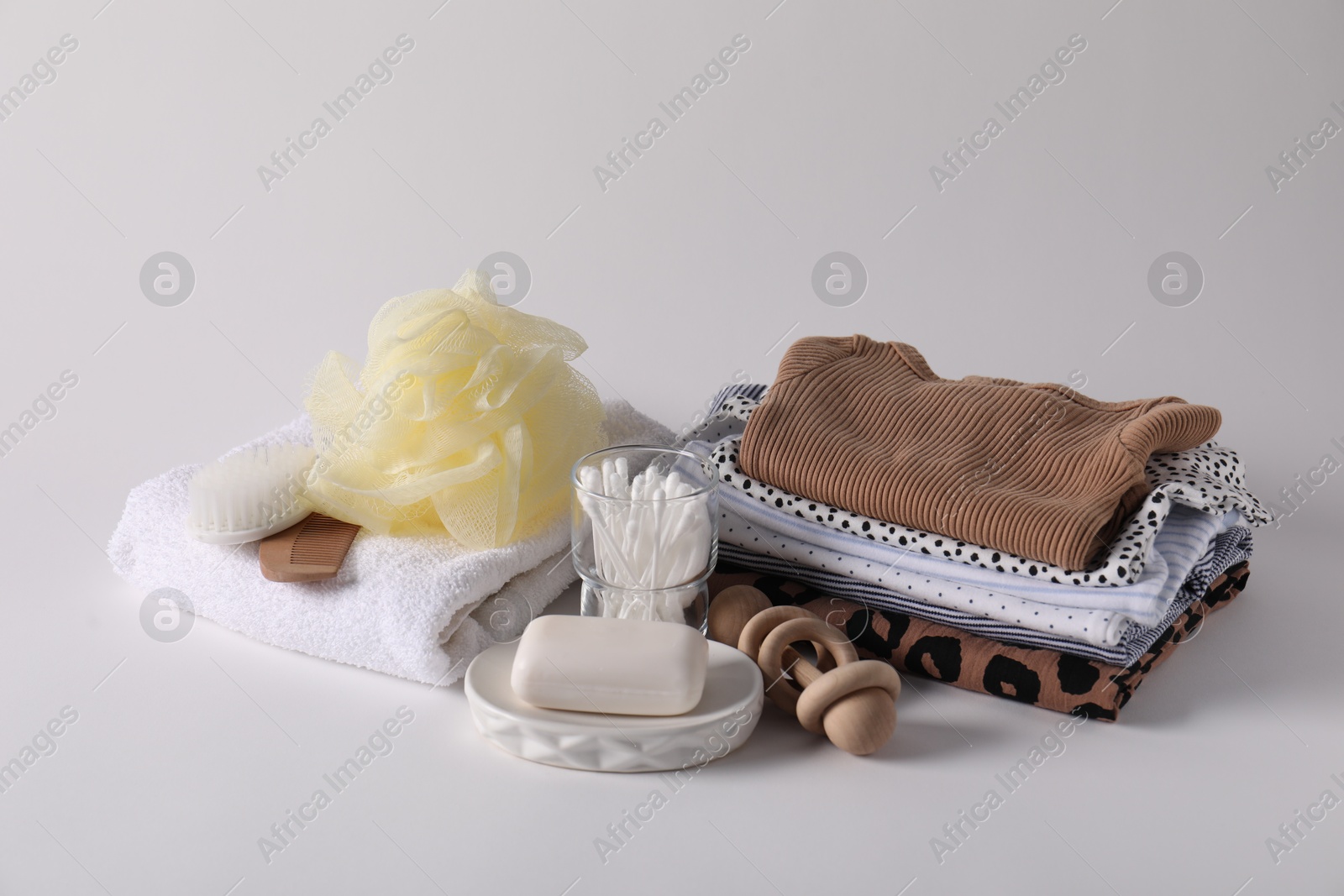 Baby accessories, clothes and body care products on light grey background Photo of Baby accessories, clothes and body care products on light grey background