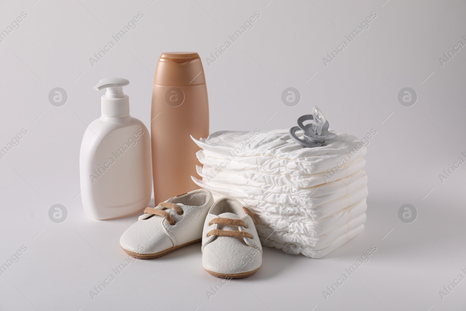 Baby accessories and body care products on light grey background Photo of Baby accessories and body care products on light grey background