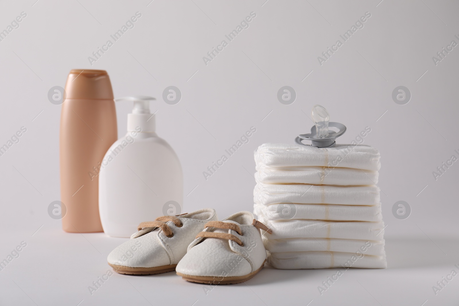 Baby accessories and body care products on light grey background Photo of Baby accessories and body care products on light grey background