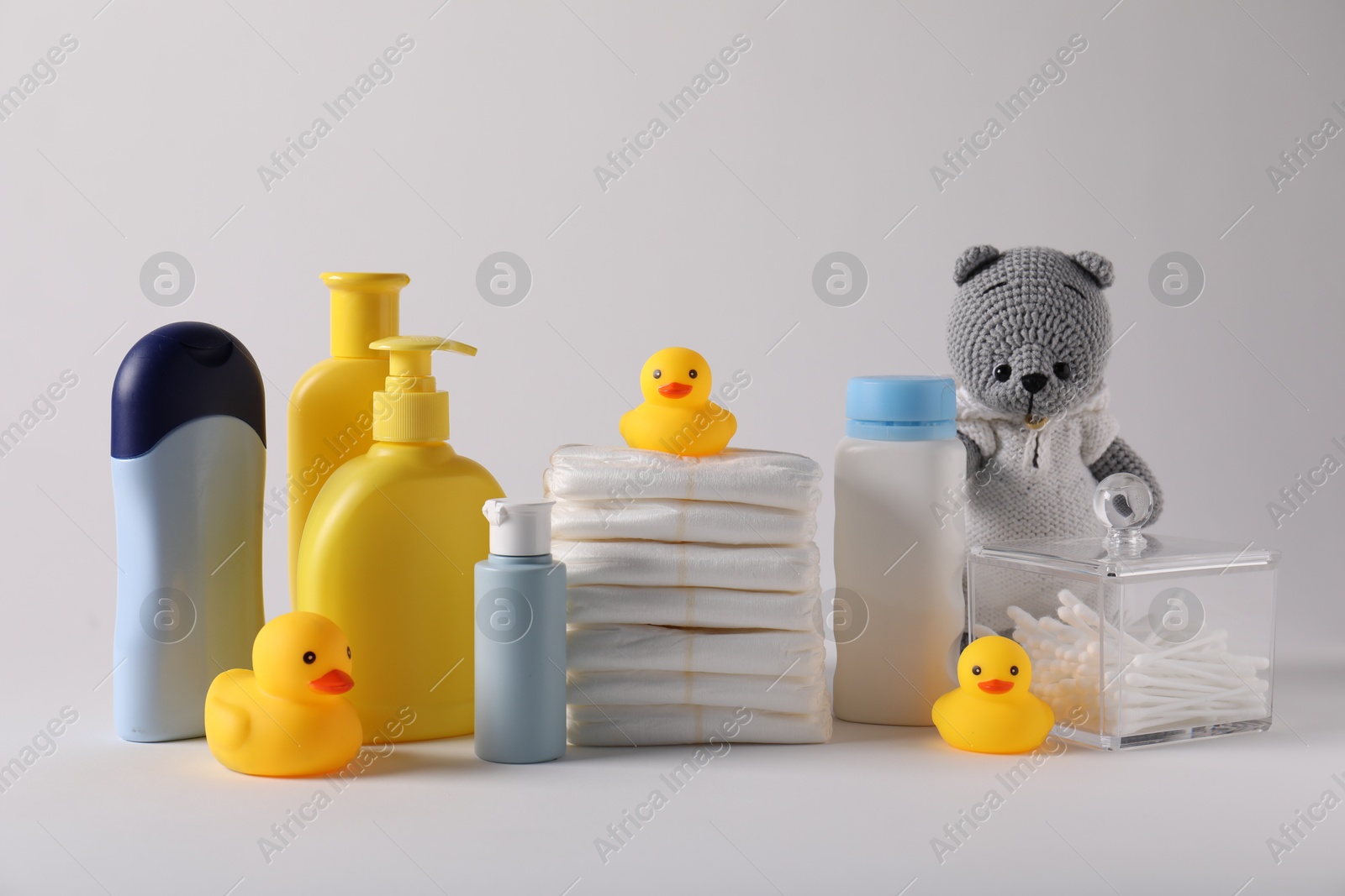 Baby accessories and body care products on light grey background Photo of Baby accessories and body care products on light grey background
