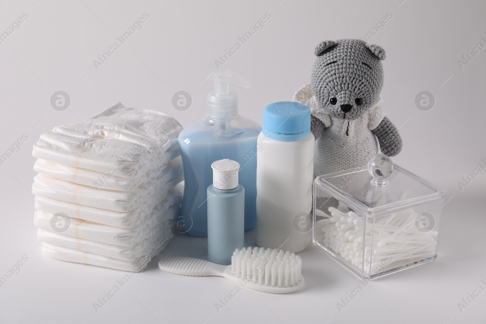 Baby accessories and body care products on light grey background Photo of Baby accessories and body care products on light grey background