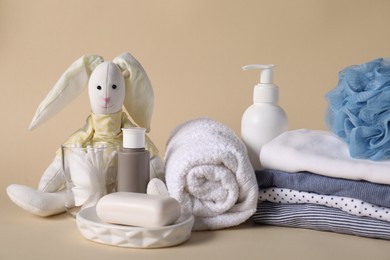 Photo of Baby accessories, clothes and body care products on beige background, closeup