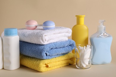 Photo of Baby accessories and body care products on beige background, closeup