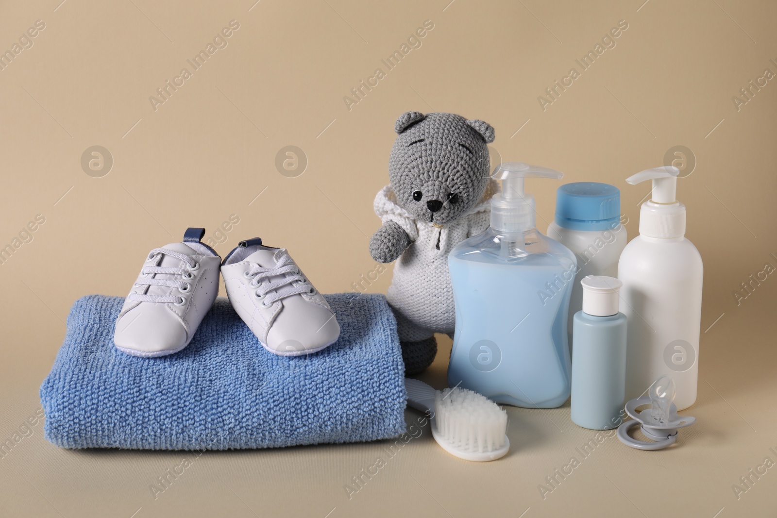 Photo of Baby accessories and body care products on beige background