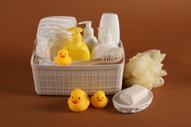 Photo of Baby accessories and body care products on brown background